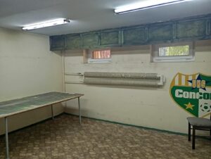 Wnętrze lokalu użytkowego przy ul. Wiosennej 2 od strony okien, stół pod ścianą